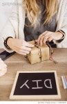 1139019449 | 게티이미지코리아 | Young woman wrapping a gift in her studio Royalty-Free 이미지