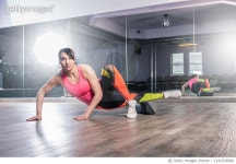 1141528546 | 게티이미지코리아 | Young woman stretching on gym floor Royalty-Free 이미지