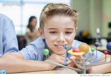 597673302 | 게티이미지코리아 | Happy little boy studying solar system model in classroom Royalty-Free 이미지