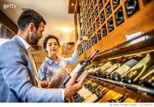 1171784734 | 게티이미지코리아 | Couple choosing from a wine rack for a bottle of wine for savoring in a luxurious restaurant... 