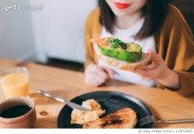 1195728525 | 게티이미지코리아 | Smiling young woman eat an avocado toast at cafe Royalty-Free 이미지