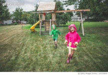 915328648 | 게티이미지코리아 | Kids running across a backyard in raincoats Royalty-Free 이미지