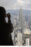 1261905052 | 게티이미지코리아 | Kuala Lumpur. Woman photographing the Petronas Towers. Royalty-Free 이미지