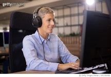 1451360388 | 게티이미지코리아 | Happy businesswoman with headphones working on PC in the office. Royalty-Free 이미지