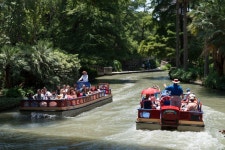 Tourist barges loaded with visitors pass each other on a portion of the San Antonio River that winds though San Antonios lively... 