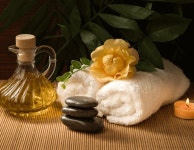 Download Spa Background Massage Oil White Towels And A Lit Candle | Wallpapers.com