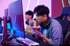  청년 남성 Pc 방 에서 컴퓨터 게임 을 하 며 라면 을 먹다