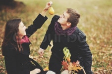 Eat this, honey. Young sweet couple having date in autumn park. | Stock Photo | Colourbox