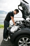 A young man fixing his car up the hills | Stock Photo | Colourbox