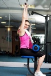 Woman toning her upper and core muscles in multi gym | Stock Photo | Colourbox