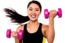 Happy fitness woman lifting dumbbells | Stock Photo | Colourbox