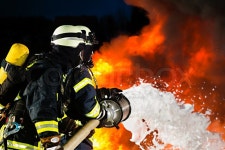 Firefighter - Firemen extinguishing a large blaze, they are standing with protective wear in front of wall of fire | Stock Photo... 