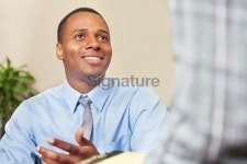 Young professional man speaking with colleague or client... 게티이미지뱅크 Young professional man speaking with colleague or client