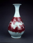 Porcelain vase of yuhuchun or pear-shaped form. Underglaze red with wide band of incised scrolling flowers left in reserve against...