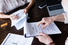 유토이미지 | Cropped view of senior man pointing at paper with debt collection lettering near gadgets and wife at home