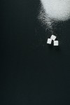 유토이미지 | top view of white sugar crystals and cubes on black background with copy space